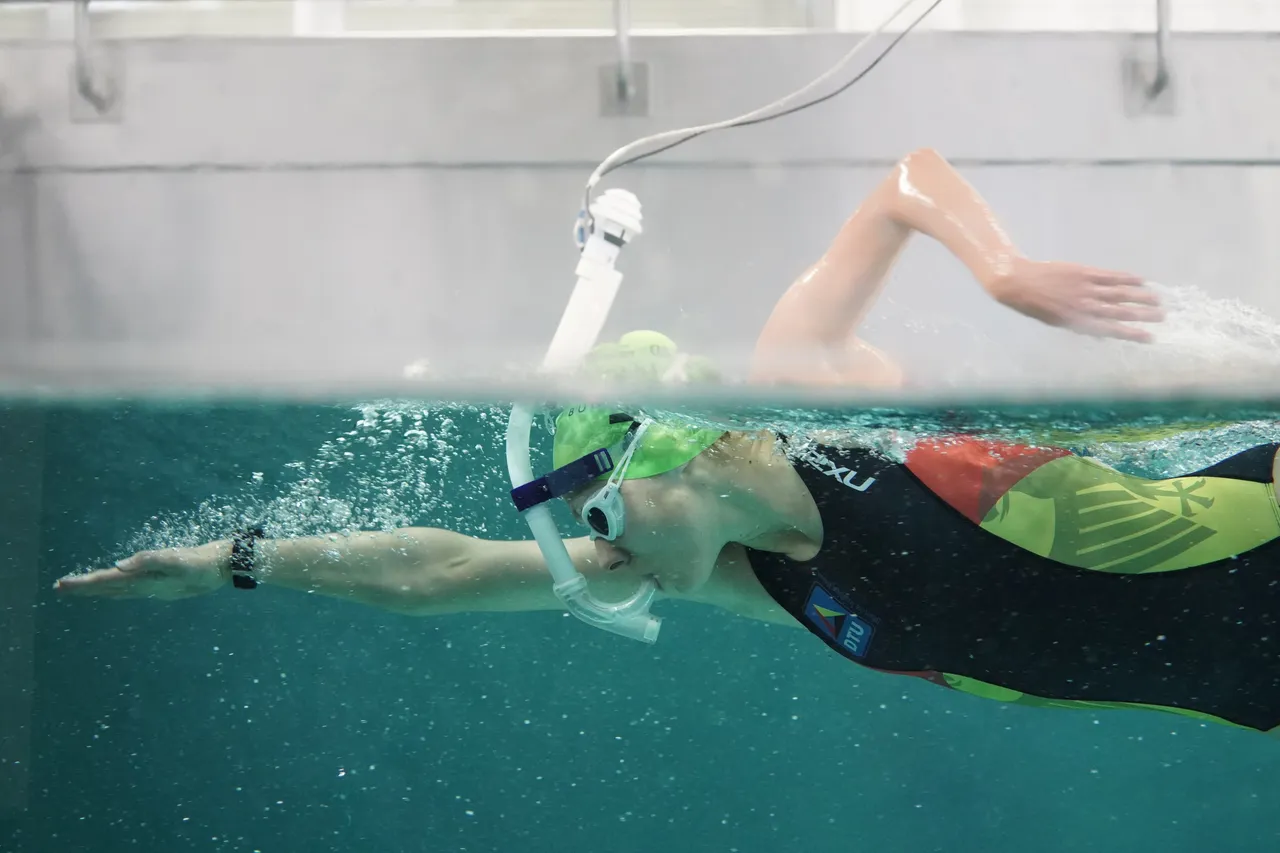 Schwimmerin beim Kraulen im Strömungskanal, über die Swim Option an die Atemgasmessung des METAMAX® 3B angeschlossen